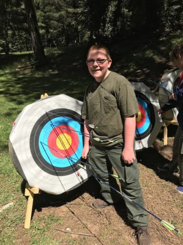 Joey by the target with arrows with author Elizabeth Van Tassel